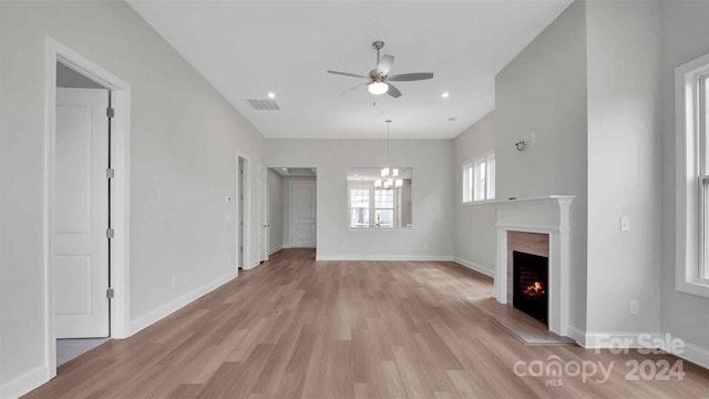 unfurnished living room with a fireplace, light hardwood / wood-style flooring, and ceiling fan