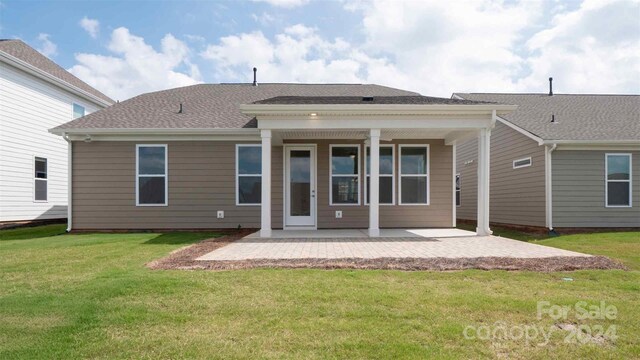 rear view of house featuring a lawn and a patio area