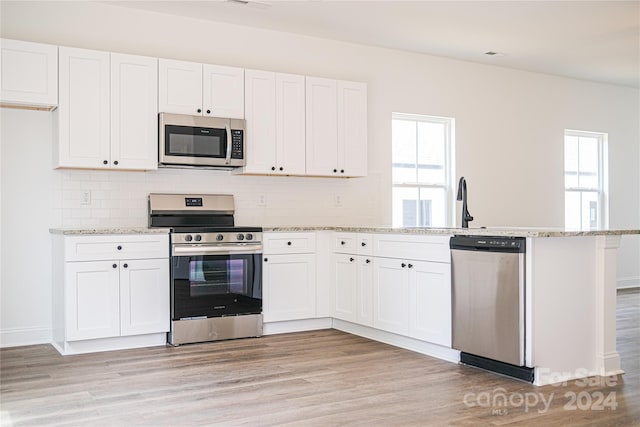 kitchen featuring white cabinetry, appliances with stainless steel finishes, and light hardwood / wood-style flooring