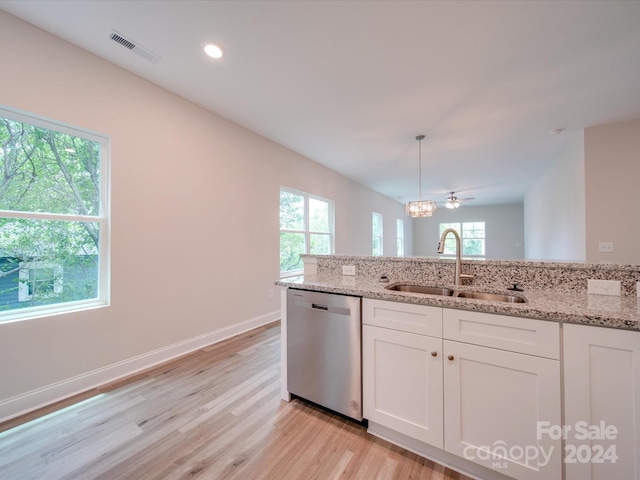 kitchen featuring dishwasher, pendant lighting, sink, white cabinetry, and light stone counters