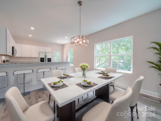 dining area featuring light hardwood / wood-style floors and a notable chandelier