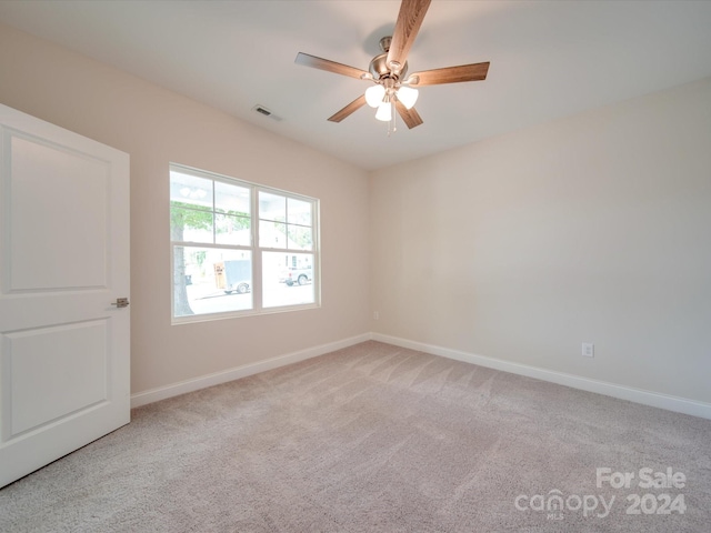 spare room featuring ceiling fan and light colored carpet