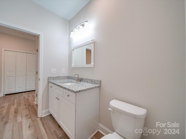 bathroom featuring toilet, hardwood / wood-style floors, and vanity