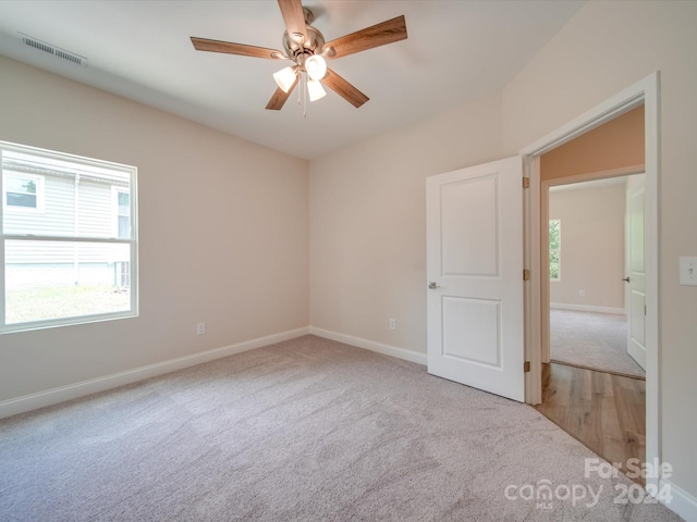 carpeted spare room with ceiling fan