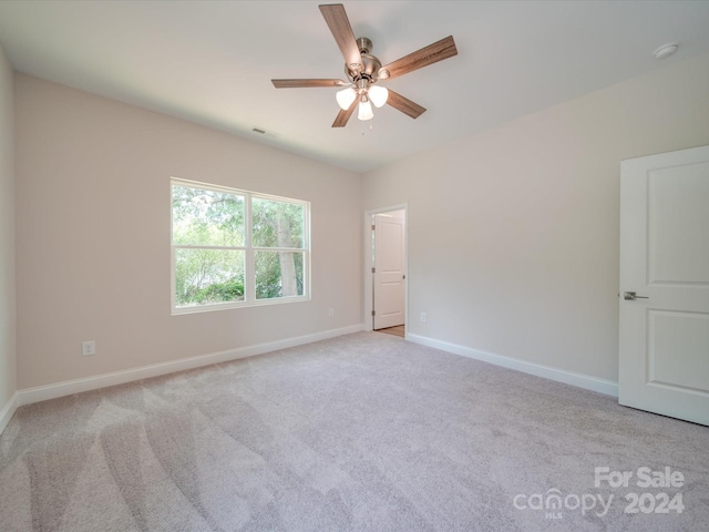 carpeted spare room featuring ceiling fan