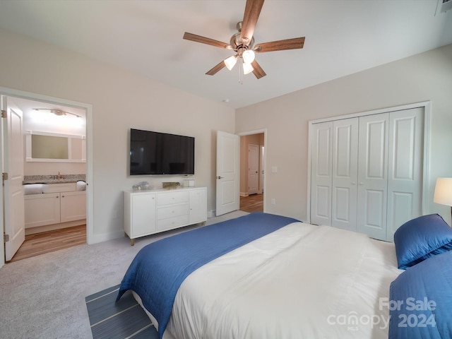 carpeted bedroom with ceiling fan, ensuite bath, and a closet