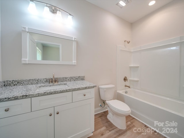 full bathroom featuring wood-type flooring, shower / bath combination, toilet, and vanity