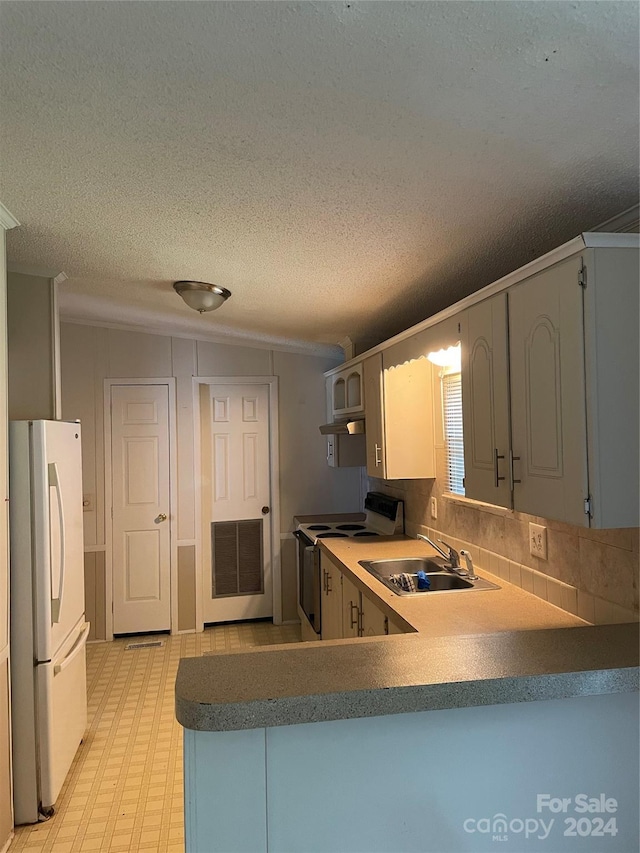 kitchen featuring kitchen peninsula, a textured ceiling, white appliances, and sink