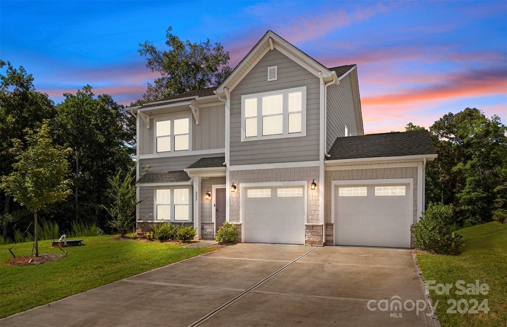 view of front of house featuring a garage and a lawn