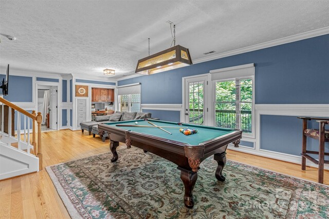 game room featuring a textured ceiling, billiards, light hardwood / wood-style flooring, and crown molding