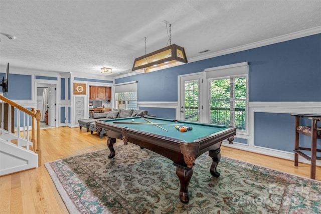 recreation room featuring ornamental molding, pool table, a textured ceiling, and light hardwood / wood-style floors