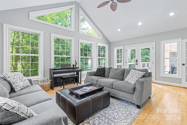 living room with ceiling fan, french doors, light wood-type flooring, and high vaulted ceiling