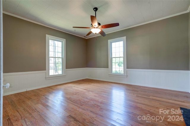 spare room with light hardwood / wood-style floors, plenty of natural light, ornamental molding, and ceiling fan