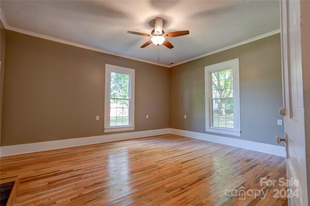 empty room with ceiling fan, a textured ceiling, ornamental molding, and light hardwood / wood-style flooring