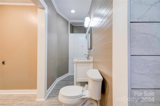 bathroom with toilet, vanity, and crown molding