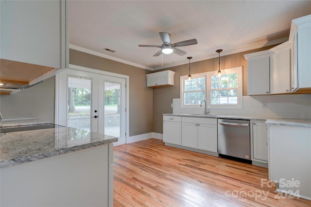 kitchen featuring stainless steel dishwasher, white cabinets, and backsplash