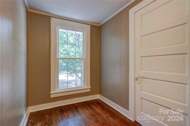 unfurnished room with dark wood-type flooring and crown molding