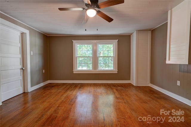 empty room with ceiling fan, ornamental molding, and wood-type flooring