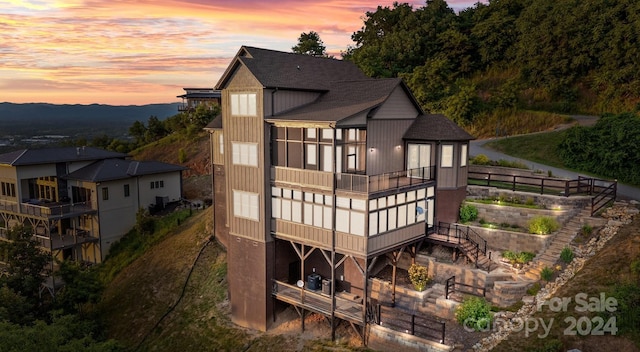 back house at dusk with a balcony