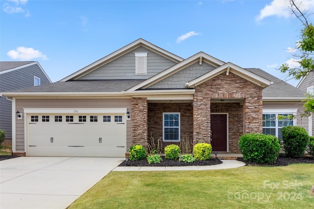 craftsman-style home featuring a garage and a front lawn