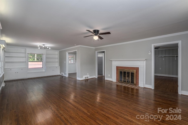 unfurnished living room featuring ceiling fan, dark wood-type flooring, a brick fireplace, built in features, and crown molding