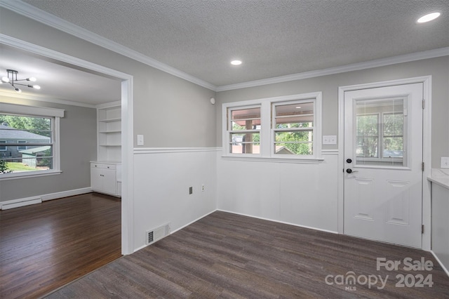 interior space featuring built in shelves, a healthy amount of sunlight, dark hardwood / wood-style flooring, and a textured ceiling