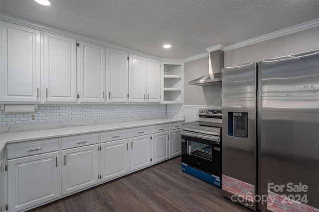 kitchen with wall chimney range hood, ornamental molding, a textured ceiling, white cabinetry, and stainless steel appliances