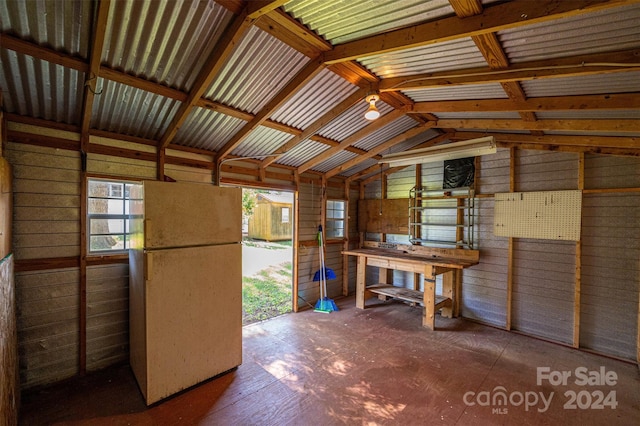 miscellaneous room with a workshop area, vaulted ceiling, and wooden walls