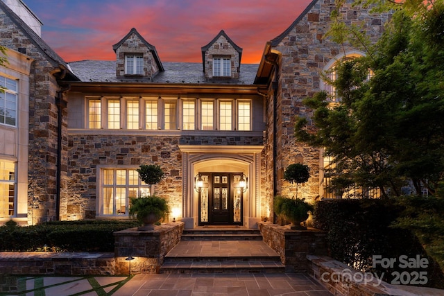 exterior entry at dusk featuring french doors