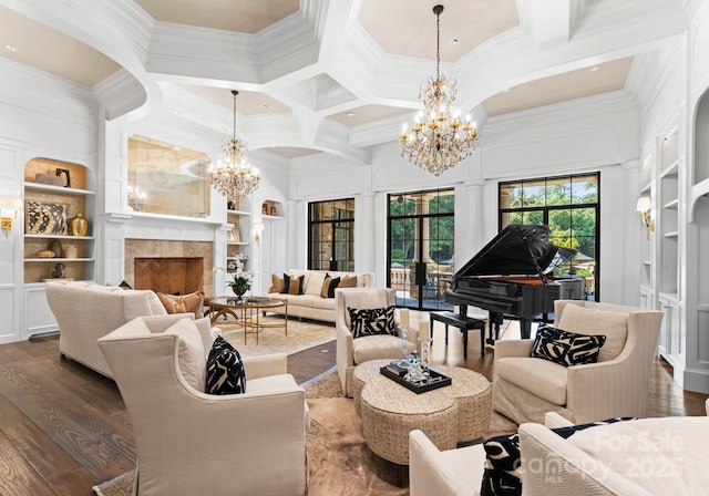 living room featuring built in shelves, dark wood-type flooring, a tile fireplace, and ornamental molding