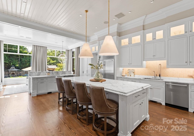 kitchen with a center island, stainless steel appliances, white cabinetry, and tasteful backsplash