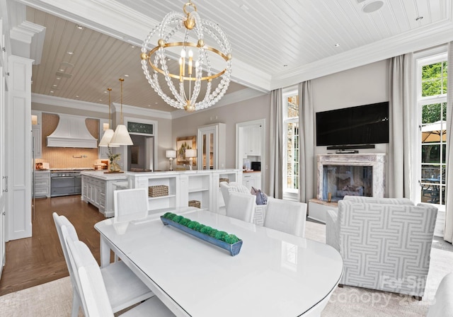 dining space featuring a notable chandelier, crown molding, a high end fireplace, and light hardwood / wood-style flooring