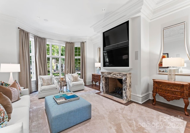 living room with hardwood / wood-style floors, crown molding, and a fireplace