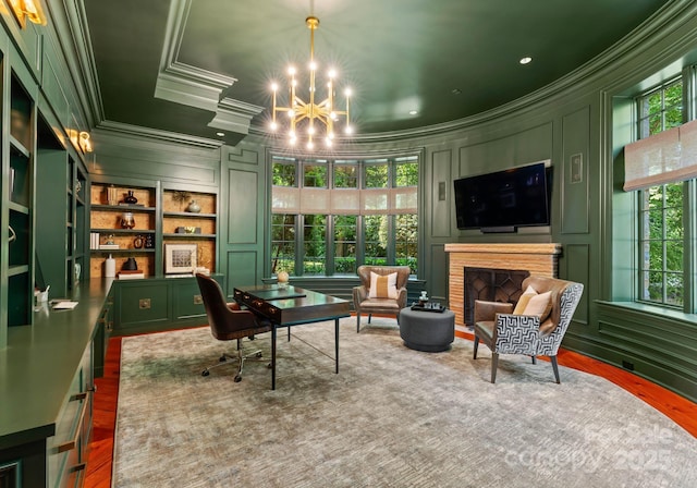 sitting room featuring crown molding, built in features, hardwood / wood-style floors, and an inviting chandelier