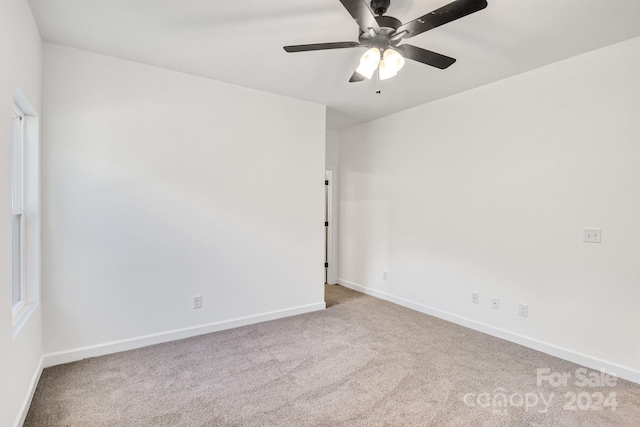 spare room featuring light carpet and ceiling fan