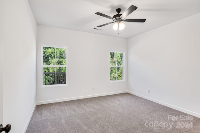 carpeted spare room with ceiling fan