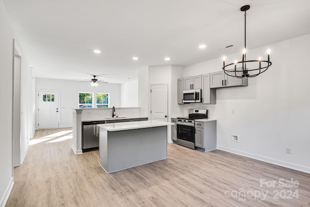 kitchen with kitchen peninsula, sink, gray cabinets, and stainless steel appliances