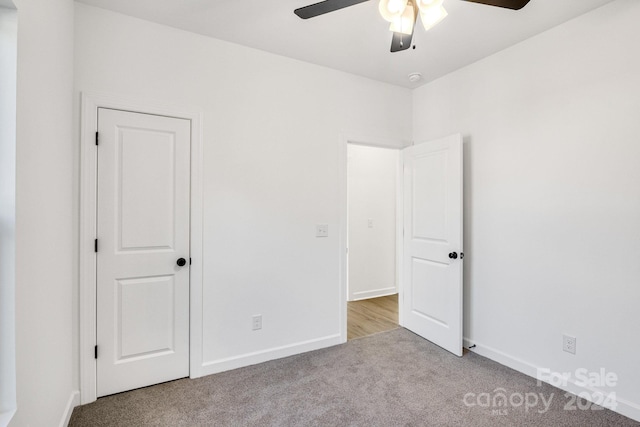 unfurnished bedroom with ceiling fan and light colored carpet