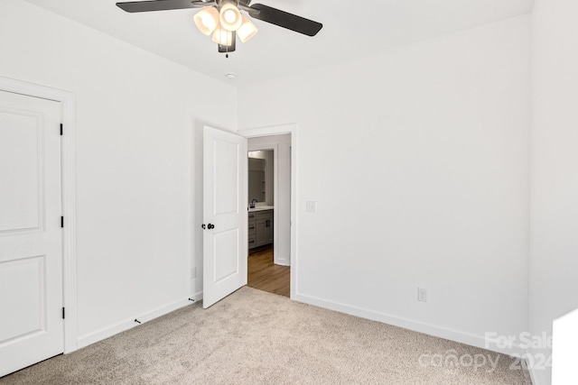 unfurnished bedroom with ceiling fan and light colored carpet