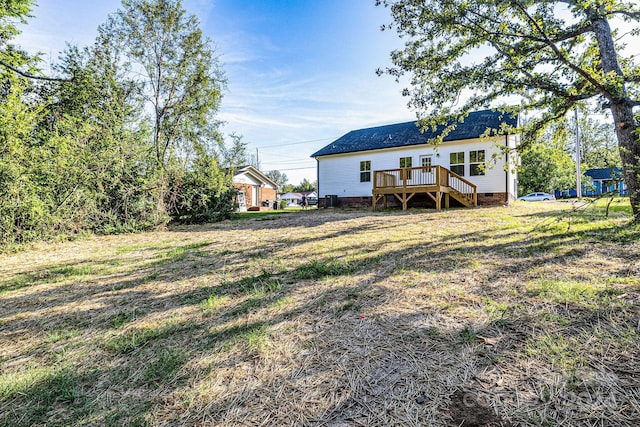 rear view of property with a deck and a lawn