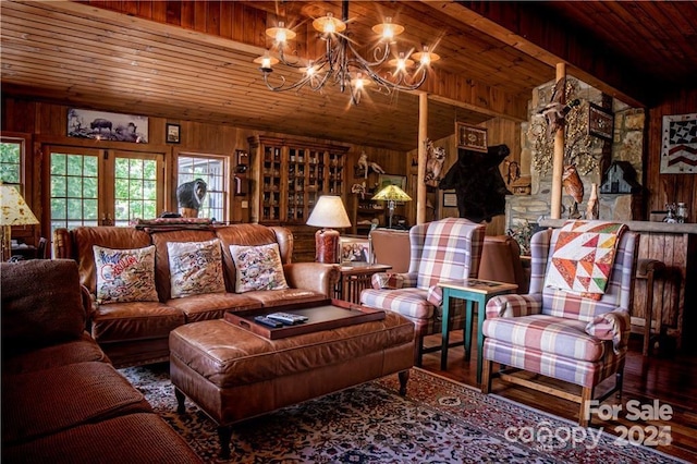 living room featuring wooden walls, wooden ceiling, french doors, an inviting chandelier, and wood finished floors