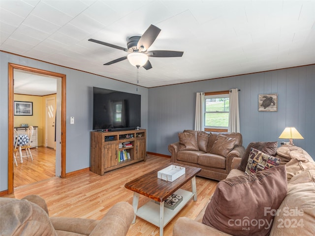 living room featuring hardwood / wood-style floors, ceiling fan, and wood walls