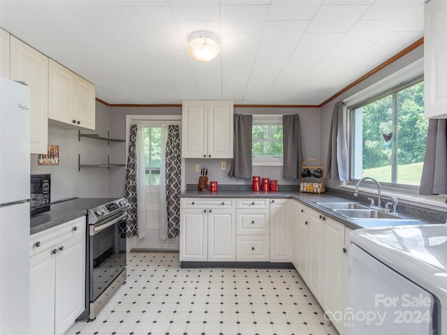 kitchen with white cabinets, plenty of natural light, sink, and stainless steel range with electric cooktop