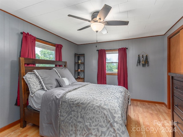 bedroom featuring multiple windows, ceiling fan, crown molding, and light hardwood / wood-style floors