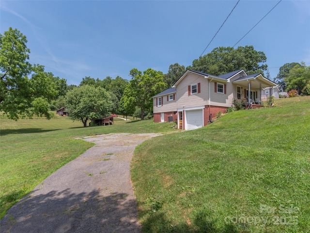 view of front facade featuring a garage, covered porch, and a front yard