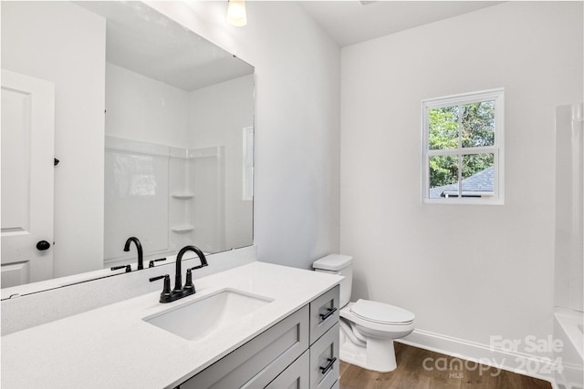 full bathroom with shower / bathtub combination, vanity, toilet, and hardwood / wood-style floors