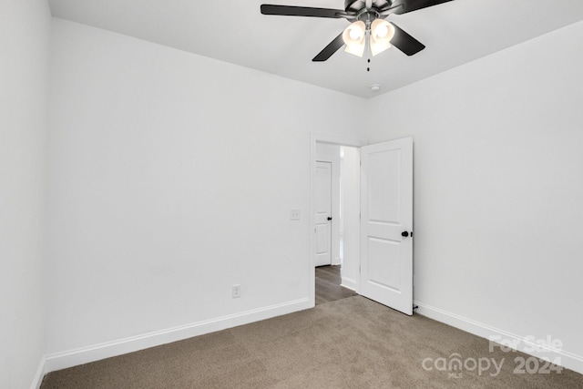 unfurnished room with dark carpet and ceiling fan