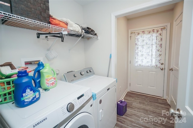 laundry area with separate washer and dryer and wood-type flooring