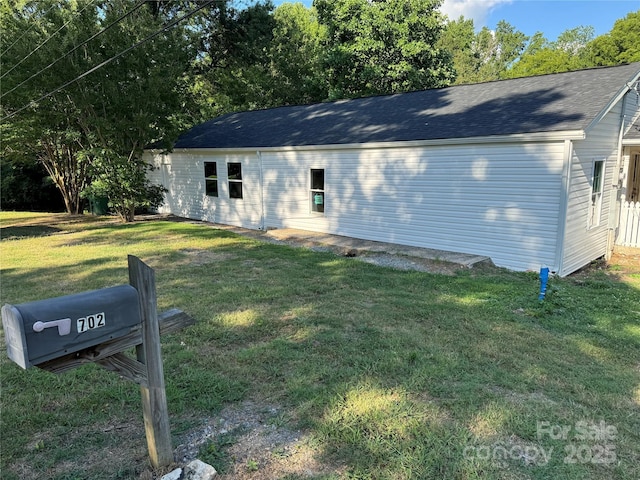 single story home featuring roof with shingles and a front lawn