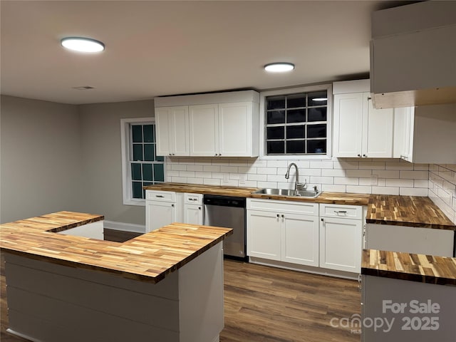 kitchen featuring dark wood-type flooring, wood counters, backsplash, and stainless steel dishwasher